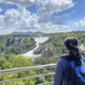 Talakad & Shivanasamudra women group trip with F5 Escapes -Women posing for a photo with the massive Shivanasamudra waterfalls in the background.