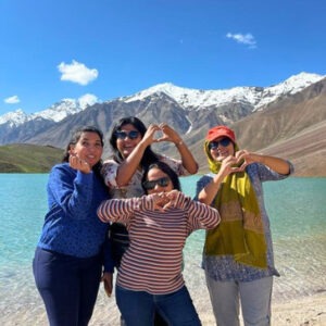 Spiti women only group tour with F5 Escapes - Group of women travelers posing in front of the stunning Chandra Taal lake in Spiti Valley.