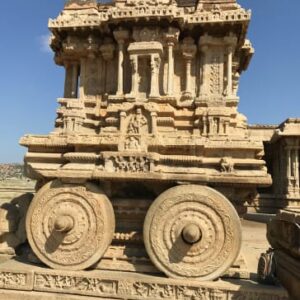 A detailed view of the iconic Stone Chariot at the Vittala Temple complex in Hampi, featuring intricate carvings and large granite wheels.