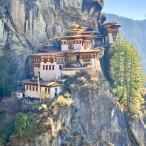 The Paro Taktsang monastery perched on a steep cliffside in Bhutan under a clear blue sky.